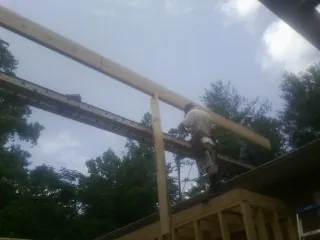 Carpenter setting a ridge beam over a new addition frame — Ice Dam Removal by Roofing Brothers in Story City