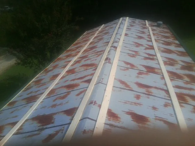 Rusted metal roof panels with new wood purlins before replacement — Storm Damage Roof Repair in Story City by Roofing Brothers