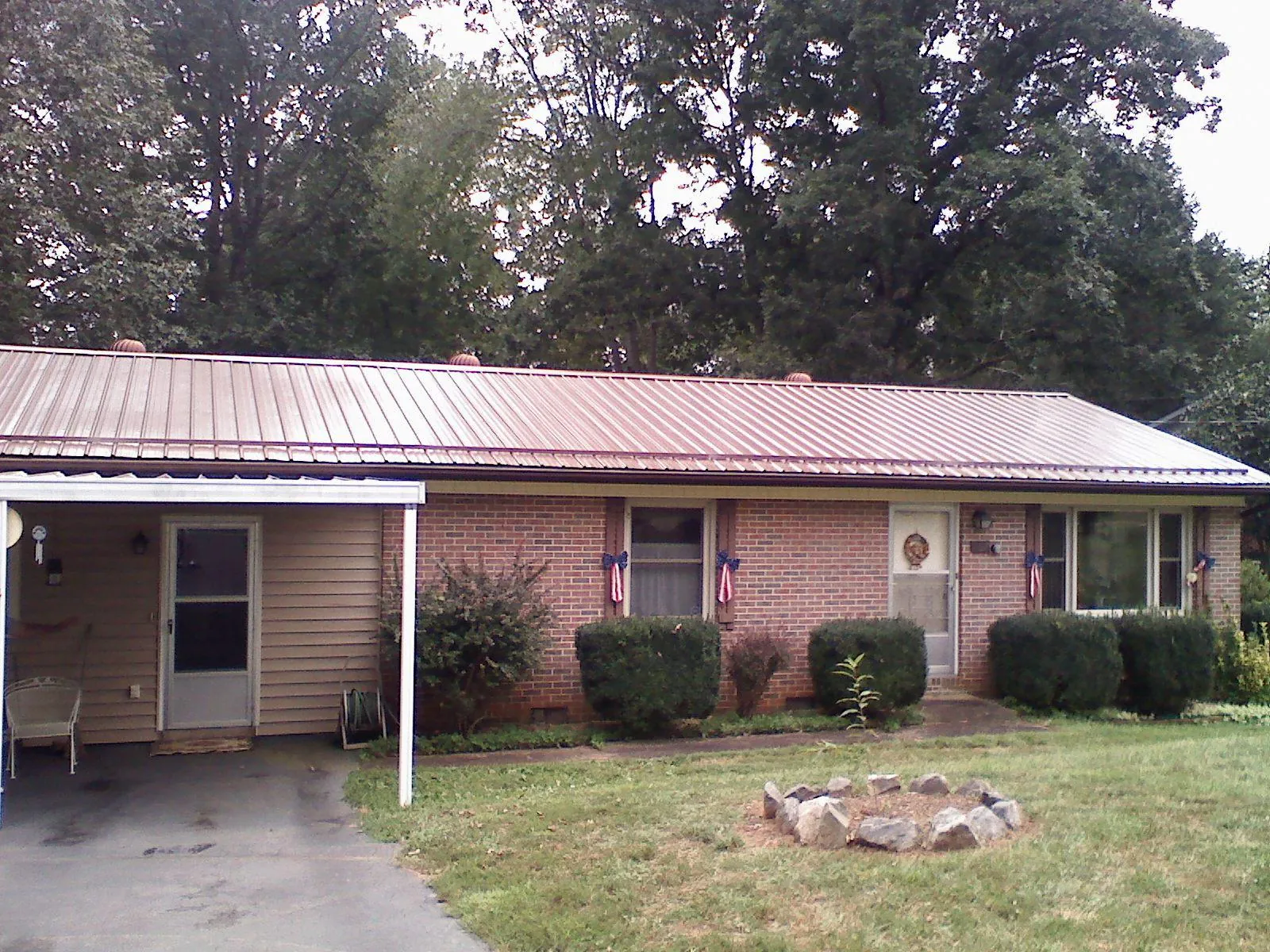 Bronze metal roof and carport on a brick ranch home — Roof Repair work by our crew in Story City